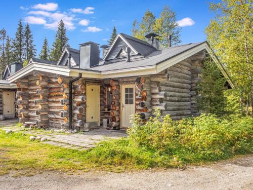 eine Blockhütte mit einer Veranda und einer gelben Tür in der Unterkunft Holiday Home Pajuruka 2 a 1 by Interhome in Ruka