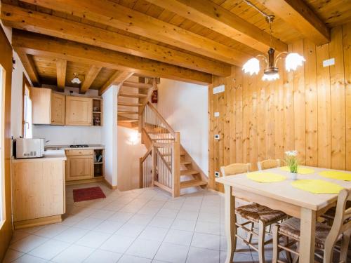kuchnia i jadalnia z drewnianymi ścianami oraz stołem i krzesłami w obiekcie Holiday Home Albergo Diffuso - Cjasa Paron Cilli by Interhome w mieście Barcis
