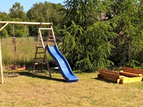 a playground with a blue slide and a ladder at Holiday Home Smołdziński Las by Interhome in Smołdziński Las