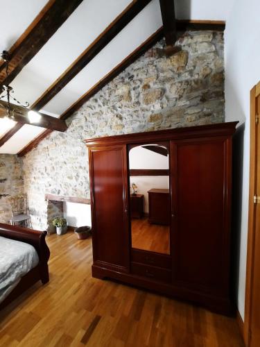 a bedroom with a large wooden cabinet with a mirror at Errotazar apartamento M in Alsasua
