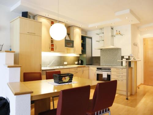 a kitchen with a wooden table with chairs and a dining room at Apartment Camping Rossbach-2 by Interhome in Nassereith