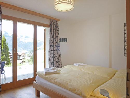 1 Schlafzimmer mit 2 Betten und einem großen Fenster in der Unterkunft Apartment Fortuna by Interhome in Wengen