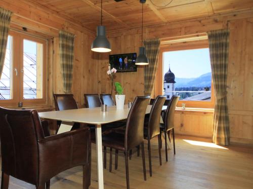 ein Esszimmer mit einem Tisch, Stühlen und einem Fenster in der Unterkunft Apartment Vitg Grond A2 by Interhome in Flims