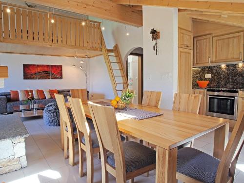 eine Küche und ein Esszimmer mit einem Holztisch und Stühlen in der Unterkunft Apartment Edelweiss A by Interhome in Leukerbad