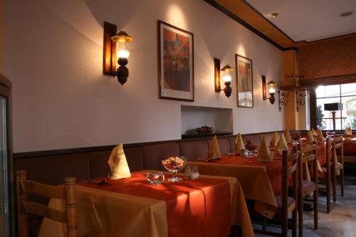 a row of tables in a restaurant with red table cloth at Le Pavillon in Echternach