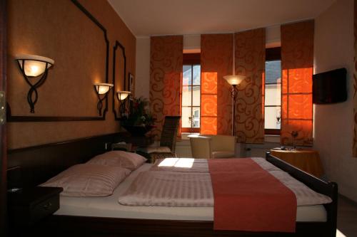 a bedroom with a bed and two lamps and windows at Le Pavillon in Echternach