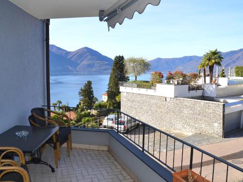 einen Balkon mit einem Tisch und Stühlen sowie Blick auf das Wasser in der Unterkunft Apartment Junior Suite Modern-20 by Interhome in Ascona