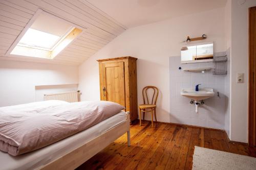 ein Schlafzimmer mit einem Bett und einem Waschbecken in der Unterkunft Ferienwohnungen Am Strandbad in Chieming