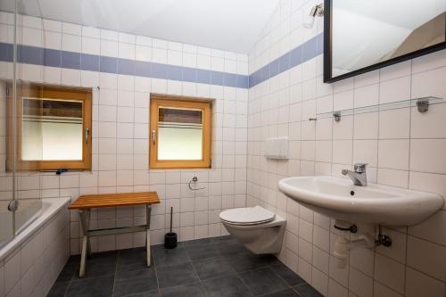 ein Badezimmer mit einem Waschbecken, einem WC und einer Badewanne in der Unterkunft Ferienwohnungen Am Strandbad in Chieming
