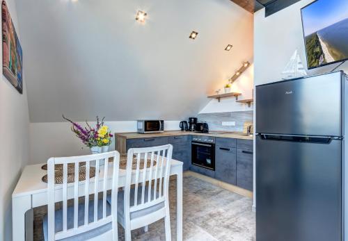 a kitchen with a refrigerator and a table and chairs at Ferienwohnung Carlotta in Trassenheide