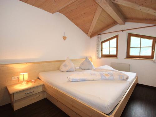 1 dormitorio con 1 cama blanca y mesita de noche en Apartment Hörhager by Interhome, en Aschau