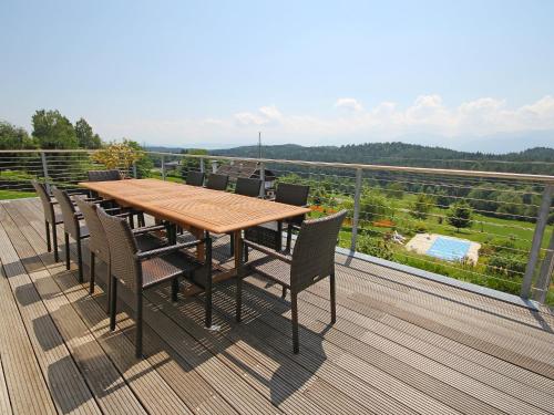 einen Holztisch und Stühle auf einer Terrasse in der Unterkunft Villa Carinthia by Interhome in Köstenberg