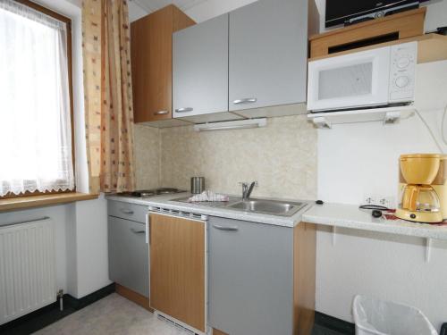 małą kuchnię z białymi szafkami i zlewem w obiekcie Apartment Falkner-1 by Interhome w mieście Oberlängenfeld