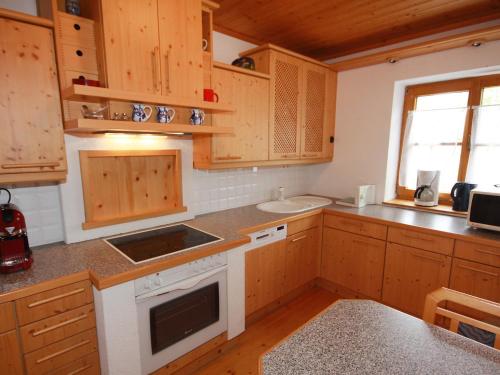 une cuisine avec des armoires en bois, un évier et une cuisinière dans l'établissement Holiday Home Almvilla by Interhome, à Sirnitz-Sonnseite