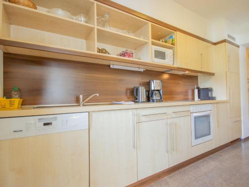 - une cuisine avec des placards en bois et un évier dans l'établissement Apartment Alpin-5 by Interhome, à Sölden