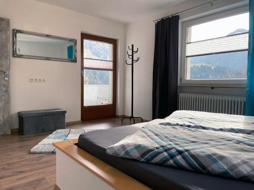ein Schlafzimmer mit einem Bett und einem großen Fenster in der Unterkunft Ferienwohnung Sunhill in Sellrain