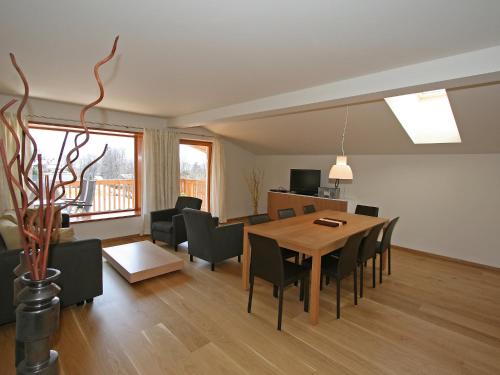 ein Esszimmer und ein Wohnzimmer mit einem Tisch und Stühlen in der Unterkunft Apartment Haus Sonne by Interhome in Erlberg