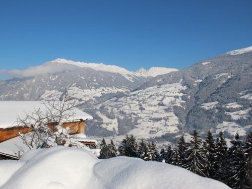 a snow covered mountain with a house in the foreground at Apartment Dornauer-2 by Interhome in Aschau