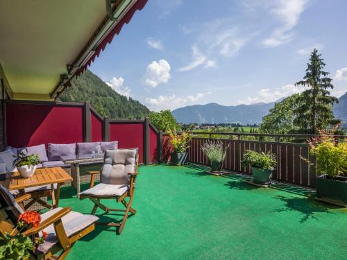 eine Terrasse mit grünen Teppichen und Stühlen auf dem Balkon in der Unterkunft Apartment Christian-4 by Interhome in Maurach