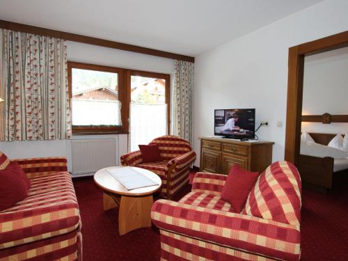 a hotel room with two couches and a television at Apartment Christian-4 by Interhome in Maurach