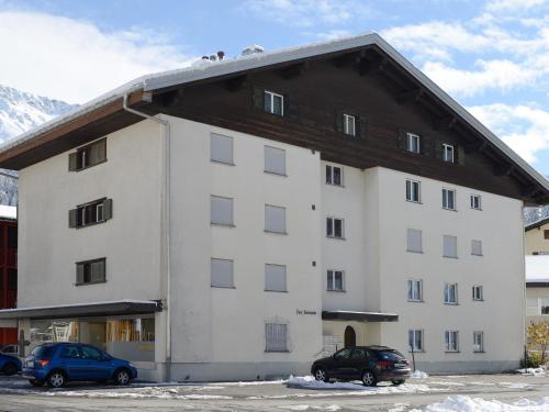 un gran edificio blanco con coches estacionados frente a él en Apartment Lang by Interhome, en Churwalden