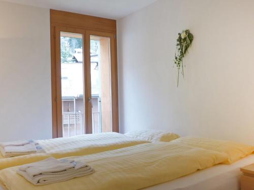 Ce lit se trouve dans un dortoir blanc doté d'une fenêtre. dans l'établissement Apartment Eden by Interhome, à Wengen