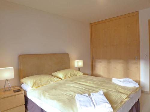 a bedroom with a bed with two pillows on it at Apartment Bella Vista-3 by Interhome in Wengen