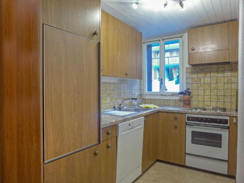 una cucina con armadi in legno e lavandino di Apartment Schweizerhof-1 by Interhome a Wengen