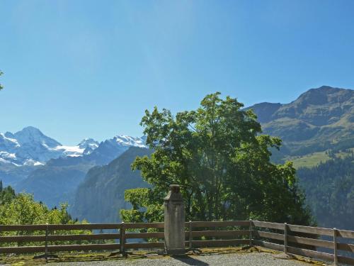 a wooden fence with mountains in the background at Apartment Schweizerhof Apt- B by Interhome in Wengen