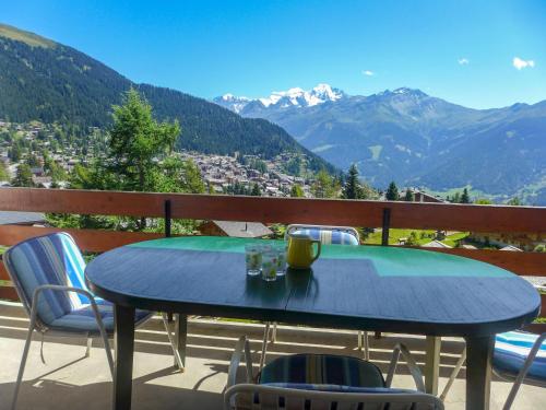 niebieski stół i krzesła na balkonie z widokiem na góry w obiekcie Apartment Butte aux Noëls 206 by Interhome w mieście Verbier