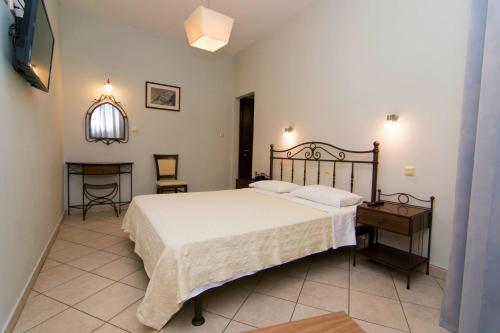 a bedroom with a bed and a table and a mirror at San Nectarios in Parga