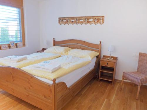 una camera con letto in legno, sedia e tavolo di Apartment Am Acher II by Interhome a Wengen