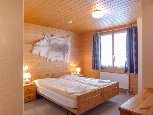 ヴェンゲンにあるApartment Chäs Gruebi by Interhomeの木製の壁のベッドルーム1室(ベッド1台付)