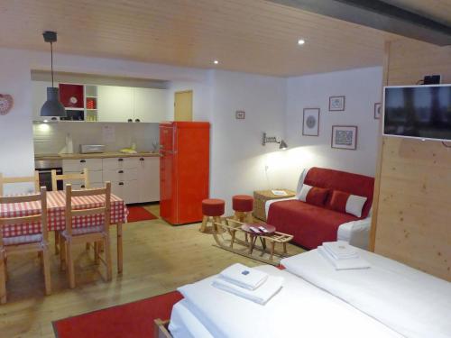 グリンデルワルトにあるApartment Chalet Almisräba by Interhomeのリビングルーム(赤いソファ付)、キッチン
