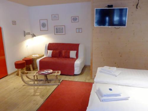 a living room with a couch and a red chair at Apartment Chalet Almisräba by Interhome in Grindelwald