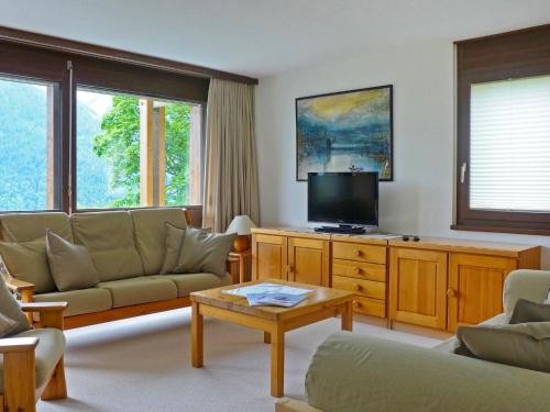 a living room with a couch and a flat screen tv at Apartment Primula Apt- B by Interhome in Wengen