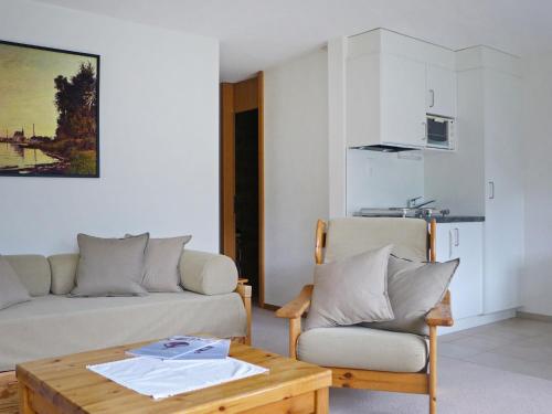 a living room with a couch and a table and a chair at Apartment Primula Apt- B by Interhome in Wengen