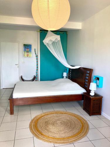 a bedroom with a large bed with a chandelier at Habitation Bellevue in Sainte-Anne