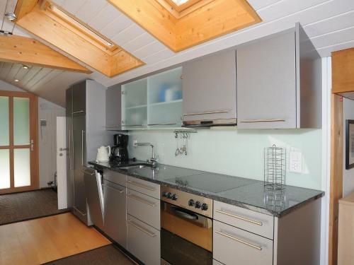 uma cozinha com electrodomésticos em aço inoxidável e tectos em madeira em Apartment Breithorn-Residence-3 by Interhome em Wengen