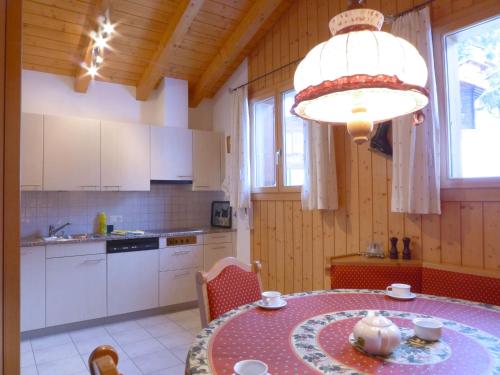 uma cozinha com uma mesa e um lustre em Apartment Roossihuus by Interhome em Wengen