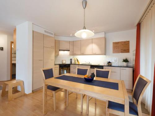 eine Küche und ein Esszimmer mit einem Holztisch und Stühlen in der Unterkunft Apartment Silberhorn-2 by Interhome in Wengen