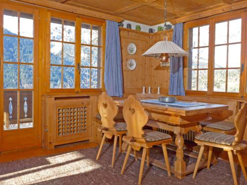 a dining room with a wooden table and chairs at Apartment Drei Tannen by Interhome in Wengen