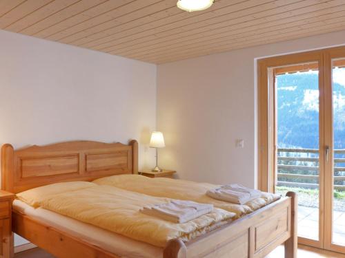 a bedroom with a bed and a large window at Apartment Racer's Retreat-1 by Interhome in Wengen