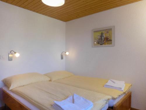 een slaapkamer met een bed met twee handdoeken erop bij Apartment Schweizerhof-2 by Interhome in Wengen