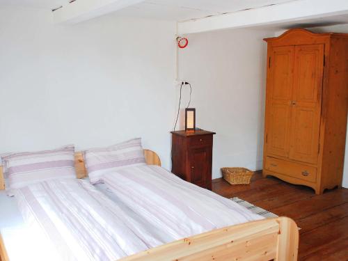um quarto com uma cama grande e um armário de madeira em Apartment Peppa by Interhome em Chironico