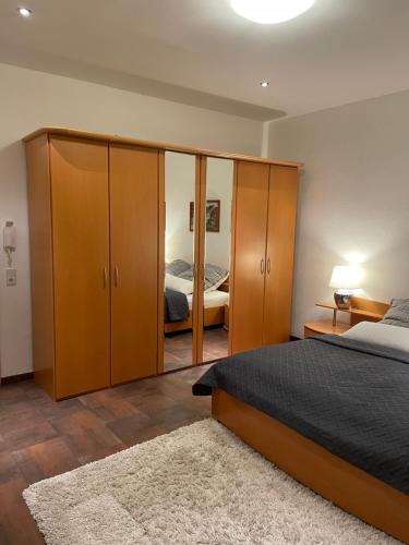 a bedroom with a bed and wooden cabinets and a mirror at Einraum Ferienwohnung im Zentrum in Aue