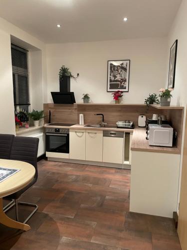 a kitchen with white cabinets and a sink and a table at Einraum Ferienwohnung im Zentrum in Aue