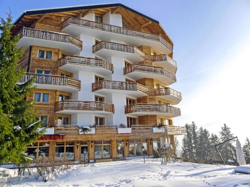 a large building with wooden balconies in the snow at Apartment Le Bristol C36 by Interhome in Villars-sur-Ollon
