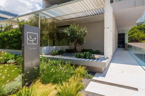 a building with a sign in front of a garden at Ogarden in Athens