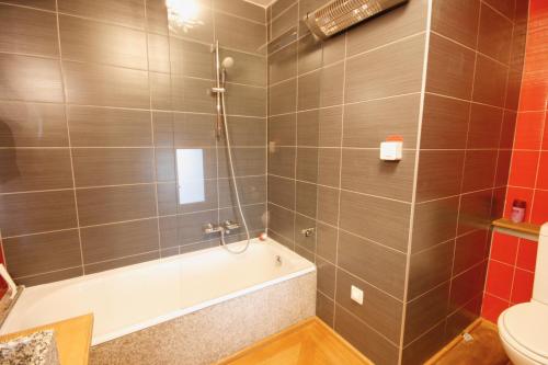 Appartement Bruat في كولمار: حمام مع دش وحوض استحمام ومرحاض